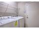 Functional laundry room with washer, dryer, wire shelving, and access to the garage at 8136 Shady Glen Ave, Las Vegas, NV 89131