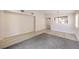 A large space with doorway leading to kitchen area, light flooring, and a large, soft area rug at 8136 Shady Glen Ave, Las Vegas, NV 89131