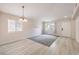 Open-concept living room with neutral walls, carpet, large window and modern chandelier lighting at 8136 Shady Glen Ave, Las Vegas, NV 89131