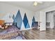 Bedroom with modern design, wood laminate flooring, mountain wall art, chair and an open closet at 8216 Brittany Harbor Dr, Las Vegas, NV 89128
