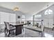 Open dining area with modern lighting, dining table, large windows and access to the living room at 8216 Brittany Harbor Dr, Las Vegas, NV 89128