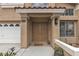 Inviting front entrance with a double door, stylish sconce lighting, and a well-manicured flower bed at 8216 Brittany Harbor Dr, Las Vegas, NV 89128