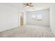 Bright bedroom with plush carpet, ceiling fan, and view of the desert landscape at 8724 Scalpay St, Las Vegas, NV 89166