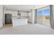 Modern open floorplan featuring kitchen with white cabinets, an island and stainless steel appliances at 8724 Scalpay St, Las Vegas, NV 89166