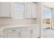 Kitchenette featuring white cabinets, quartz countertops, herringbone backsplash and a window at 8724 Scalpay St, Las Vegas, NV 89166