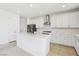 Well-lit kitchen boasting a large island, white cabinets, and stainless steel appliances at 8724 Scalpay St, Las Vegas, NV 89166