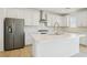 Stylish kitchen with a stainless steel refrigerator, white cabinetry, and a spacious island at 8724 Scalpay St, Las Vegas, NV 89166