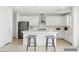 Clean, white kitchen boasts a center island with seating, stainless steel appliances, and tiled backsplash at 8724 Scalpay St, Las Vegas, NV 89166