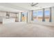 Bright, open-concept living area with neutral carpet, large windows, and access to the kitchen at 8724 Scalpay St, Las Vegas, NV 89166