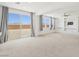 Bright, open living area featuring neutral carpet, built-in shelving, and a backyard view at 8724 Scalpay St, Las Vegas, NV 89166