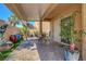 Covered back patio showcasing a stone-paver floor, outdoor seating, and decorative accents at 9215 Penn Station St, Las Vegas, NV 89123