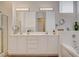 Bright bathroom featuring double sinks, large mirrors, and a separate glass-enclosed shower at 9215 Penn Station St, Las Vegas, NV 89123