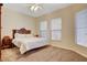 Neutral bedroom featuring a decorative headboard, carpeted floors, and two windows at 9215 Penn Station St, Las Vegas, NV 89123
