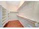 Walk-in closet with wood floors, built-in shelving, and bright white walls at 9215 Penn Station St, Las Vegas, NV 89123