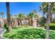 Community pool with covered area, palm trees, and manicured landscaping, creating a relaxing atmosphere at 9215 Penn Station St, Las Vegas, NV 89123