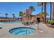 Community hot tub by the pool area, with lounge chairs and a shaded seating area among palm trees at 9215 Penn Station St, Las Vegas, NV 89123