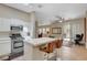 Open-concept kitchen with stainless steel appliances, island seating, and wood flooring at 9215 Penn Station St, Las Vegas, NV 89123