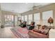 Bright living room with a sliding glass door, leather chairs, and a cozy area rug on wood floors at 9215 Penn Station St, Las Vegas, NV 89123