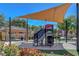 Community playground with climbing structure, swings, and covered picnic area, surrounded by colorful foliage at 9215 Penn Station St, Las Vegas, NV 89123