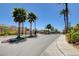 Street view of a gated community entrance with lush landscaping and manicured lawns at 9215 Penn Station St, Las Vegas, NV 89123