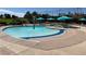 Inviting community pool with vibrant blue umbrellas, shallow wading area and mature landscaping at 9409 January Dr, Las Vegas, NV 89134