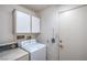 Functional laundry room with washer, dryer, white cabinets, and convenient access to the outdoors at 9409 January Dr, Las Vegas, NV 89134