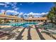 Community pool surrounded by lounge chairs, tables, and lush landscaping at 9409 January Dr, Las Vegas, NV 89134