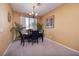 Inviting dining room with a chandelier, neutral walls, and large windows with peaceful outside views at 9516 Belgate Ct, Las Vegas, NV 89129