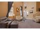 Spacious living room with high ceilings, plush seating, a staircase, and plenty of natural light at 9516 Belgate Ct, Las Vegas, NV 89129