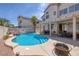 Inviting pool with rock features, a tanning ledge, and covered patio, perfect for outdoor entertaining at 9516 Belgate Ct, Las Vegas, NV 89129