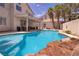 Inviting backyard pool with rock waterfall feature and covered patio area at 9516 Belgate Ct, Las Vegas, NV 89129