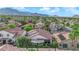 Expansive view of home with mountain backdrop in a lush, green community at 9705 Cameo Rose Ln, Las Vegas, NV 89134