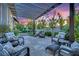 Cozy outdoor patio area with stylish furniture, pergola, and beautifully landscaped backyard at 9705 Cameo Rose Ln, Las Vegas, NV 89134