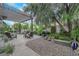 Serene backyard featuring seating beneath a pergola and stone landscaping with mature shade trees at 9705 Cameo Rose Ln, Las Vegas, NV 89134