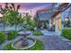 Inviting backyard with a decorative fountain, cozy seating under a pergola, and lush landscaping at 9705 Cameo Rose Ln, Las Vegas, NV 89134