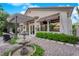 Landscaped backyard with patio, pergola, water fountain, manicured greenery, and privacy wall at 9705 Cameo Rose Ln, Las Vegas, NV 89134