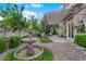 Secluded backyard featuring water fountain, verdant landscaping, and an inviting covered patio at 9705 Cameo Rose Ln, Las Vegas, NV 89134