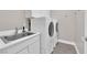 Laundry room with white appliances, basin sink, and white cabinets at 9705 Cameo Rose Ln, Las Vegas, NV 89134