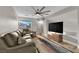 Inviting living room with comfortable seating, a large ceiling fan, and plenty of natural light at 9705 Cameo Rose Ln, Las Vegas, NV 89134