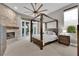 Bedroom with four poster bed, stone fireplace, and access to outdoor patio at 9705 Cameo Rose Ln, Las Vegas, NV 89134