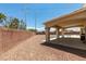 Backyard featuring a covered patio, desert landscaping, and ample room for outdoor activities at 10290 Marion Morrison Ct, Las Vegas, NV 89183