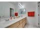 Bright bathroom featuring a double sink vanity with neutral countertops and a large mirror at 10290 Marion Morrison Ct, Las Vegas, NV 89183
