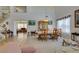 Bright living and dining area featuring high ceilings, an open staircase, tile floors, and seamless transitions at 10290 Marion Morrison Ct, Las Vegas, NV 89183