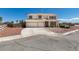 Two story home featuring a two-car garage, desert landscaping, and a charming white picket fence at 10290 Marion Morrison Ct, Las Vegas, NV 89183