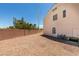 Exterior view of the home with desert landscaping, a small covered patio, and ample space at 10290 Marion Morrison Ct, Las Vegas, NV 89183