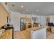 Kitchen with granite counters, stainless steel refrigerator, and adjacent staircase to the upper level, plus informal dining area at 10290 Marion Morrison Ct, Las Vegas, NV 89183