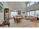 Bright living room featuring high ceilings, large windows, and comfortable seating arrangements, and a formal dining area at 10290 Marion Morrison Ct, Las Vegas, NV 89183