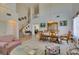Bright living room featuring high ceilings, an open staircase, tile floors, and carpeted area at 10290 Marion Morrison Ct, Las Vegas, NV 89183