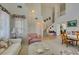 Spacious living room showcasing high ceilings, an open staircase, tile floors, and a seamless transition at 10290 Marion Morrison Ct, Las Vegas, NV 89183