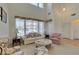 Bright living room featuring high ceilings, large windows, and a traditional style with carpeted floors at 10290 Marion Morrison Ct, Las Vegas, NV 89183